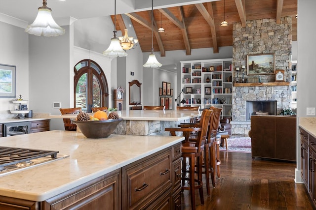 6835 Jasper Highlands Blvd, Jasper, TN 37347 - kitchen with a wooden ceiling with exposed beams, dark wood-style flooring, a kitchen bar, a large island, and a stone fireplace
