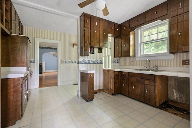 20 Ridge Rd, Chattanooga, TN 37411 - kitchen with wallpapered walls, ceiling fan, wainscoting, arched walkways, and light tile patterned flooring