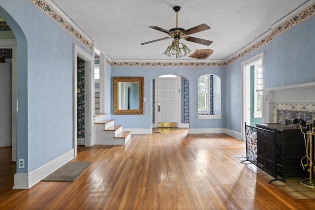 20 Ridge Rd, Chattanooga, TN 37411 - unfurnished living room with arched walkways, wood-type flooring, ceiling fan, a textured ceiling, and stairway