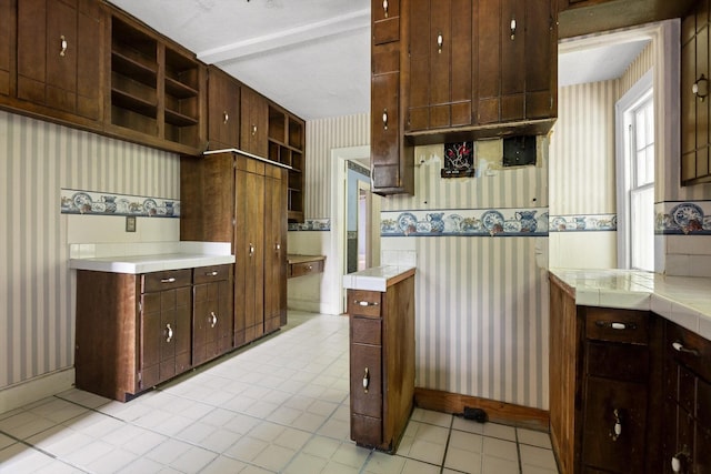 20 Ridge Rd, Chattanooga, TN 37411 - kitchen featuring wallpapered walls, open shelves, light tile patterned flooring, dark brown cabinetry, and tile countertops