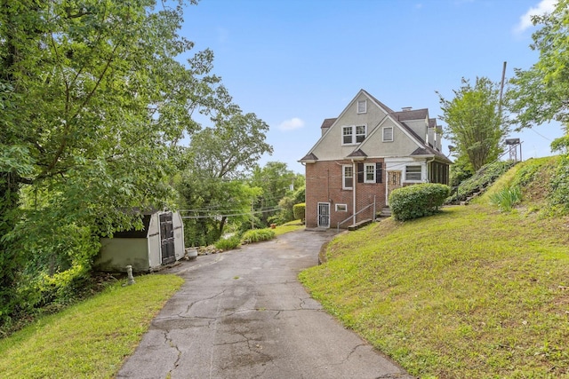 20 Ridge Rd, Chattanooga, TN 37411 - view of front of house featuring a chimney, driveway, brick siding, a front lawn, and an outbuilding