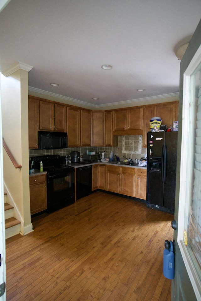 808 Fairview Ave, Chattanooga, TN 37403 - kitchen with black appliances, backsplash, dark wood-type flooring, brown cabinets, and ornamental molding