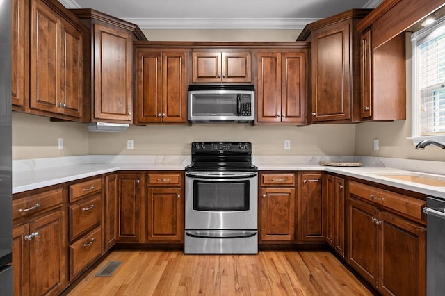 6970 Bullock Way, Hixson, TN 37343 - kitchen with appliances with stainless steel finishes, crown molding, light wood-type flooring, and light countertops