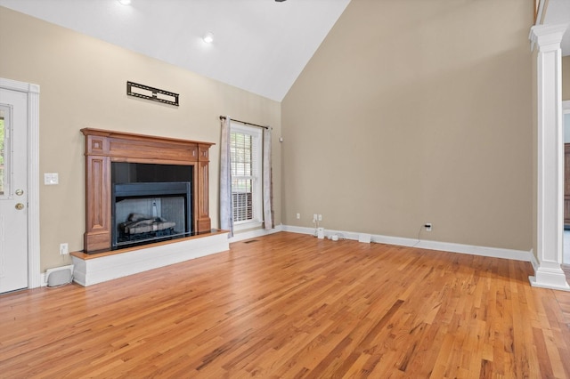 6970 Bullock Way, Hixson, TN 37343 - unfurnished living room featuring decorative columns, light wood-style floors, a fireplace with raised hearth, and high vaulted ceiling