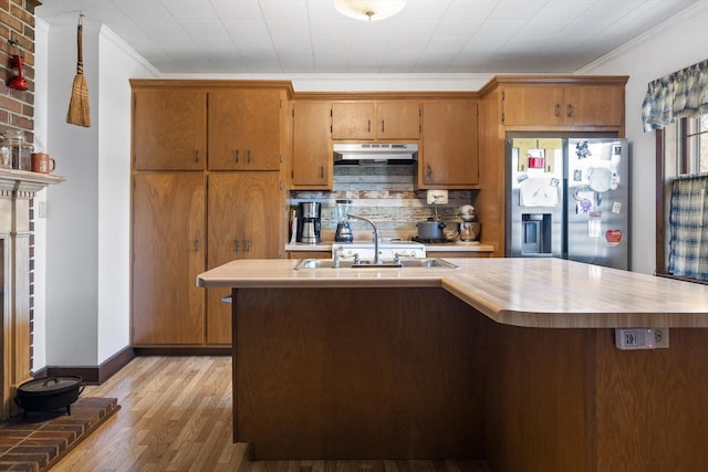 3216 Cleveland Hwy, Dalton, GA 30721 - kitchen featuring stainless steel fridge, under cabinet range hood, light countertops, ornamental molding, and light wood finished floors