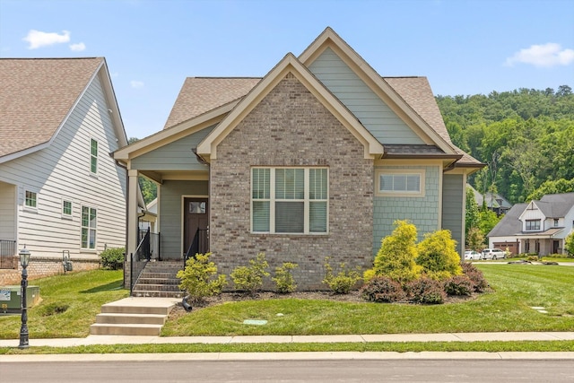 9614 Mulberry Gap Way, Ooltewah, TN 37363 - view of front facade with brick siding, roof with shingles, a front lawn, and a porch