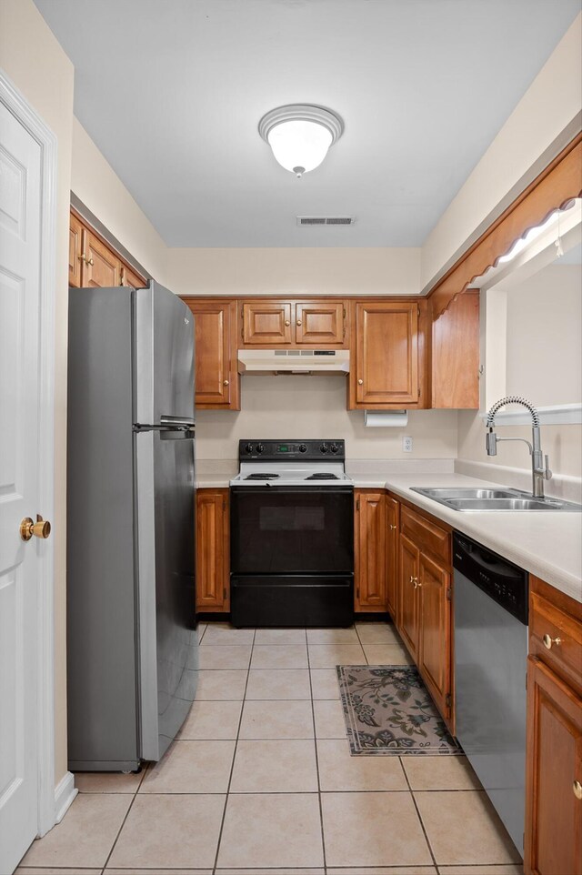 6585 Hickory Trace Cir, Chattanooga, TN 37421 - kitchen with appliances with stainless steel finishes, under cabinet range hood, light countertops, light tile patterned floors, and brown cabinets