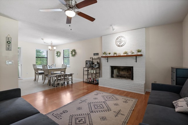 411 Meadow Green Dr, Ringgold, GA 30736 - living area with a fireplace, a ceiling fan, wood finished floors, and a chandelier