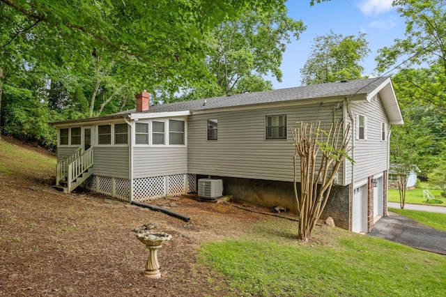 7622 Cove Ridge Dr, Hixson, TN 37343 - back of property featuring a chimney, driveway, an attached garage, and a sunroom