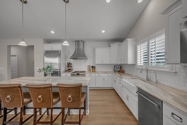 7192 Winfrey Dr, Fairview, TN 37062 - kitchen featuring appliances with stainless steel finishes, wall chimney range hood, tasteful backsplash, white cabinets, and recessed lighting