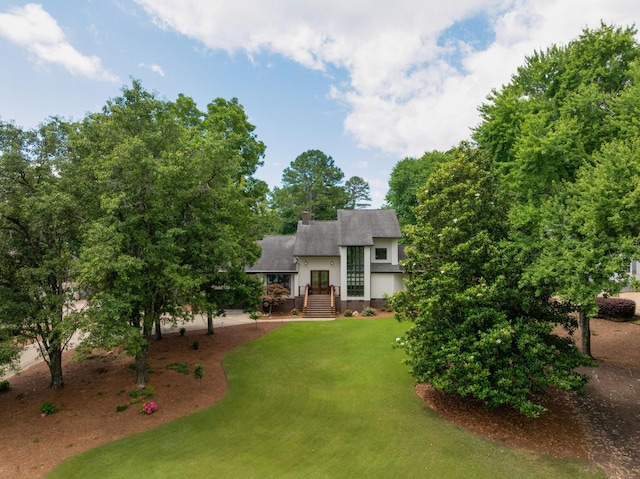 9208 Windstone Dr, Ooltewah, TN 37363 - view of front facade with stucco siding, a front yard, a chimney, and roof with shingles