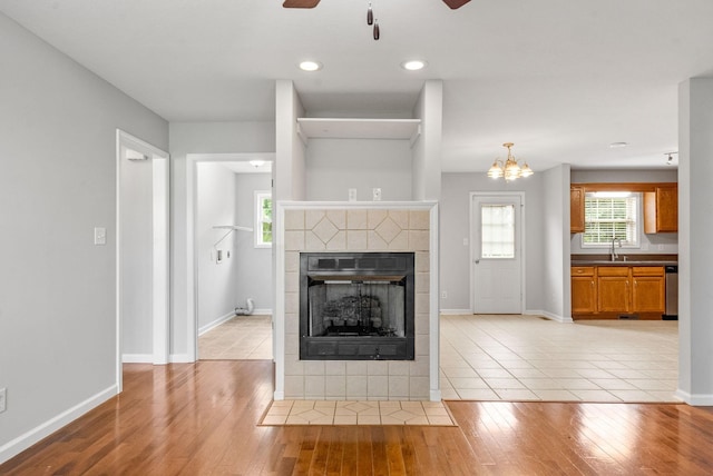 3366 N Henderson Way, Clarksville, TN 37042 - unfurnished living room featuring a ceiling fan, a tile fireplace, light wood-style flooring, plenty of natural light, and recessed lighting