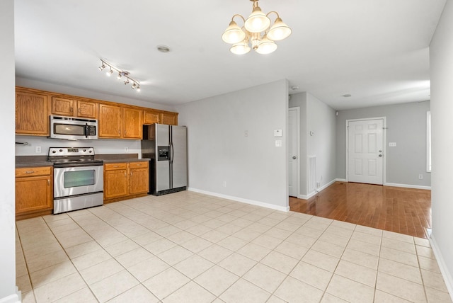 3366 N Henderson Way, Clarksville, TN 37042 - kitchen featuring appliances with stainless steel finishes, a chandelier, dark countertops, and brown cabinets