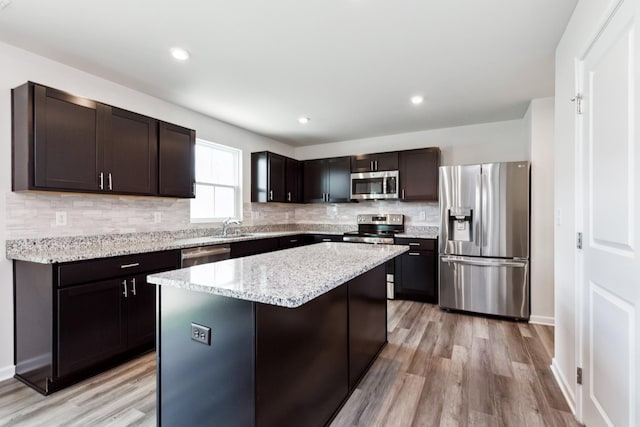 1802 Quail Run Way, Spring Hill, TN 37174 - kitchen with appliances with stainless steel finishes, tasteful backsplash, light wood-type flooring, a kitchen island, and recessed lighting