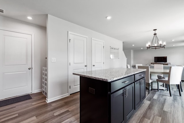 1802 Quail Run Way, Spring Hill, TN 37174 - kitchen featuring dark wood-type flooring, a kitchen island, hanging light fixtures, light stone counters, and a chandelier