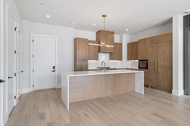 321 31st Ave N Unit B1 B, Nashville, TN 37203 - kitchen with modern cabinets, black oven, an island with sink, brown cabinets, and recessed lighting