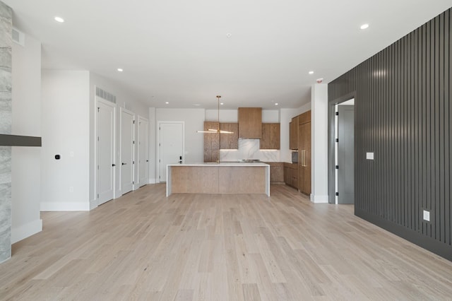 321 31st Ave N Unit B1 B, Nashville, TN 37203 - kitchen with brown cabinets, light wood-type flooring, open floor plan, modern cabinets, and a kitchen island with sink