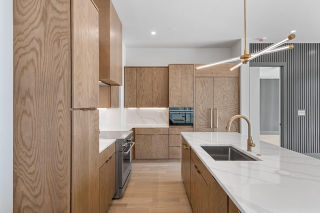 321 31st Ave N Unit B1 B, Nashville, TN 37203 - kitchen featuring stainless steel stove, modern cabinets, brown cabinetry, light wood-style flooring, and light stone countertops