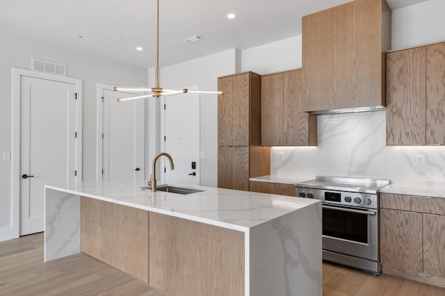 321 31st Ave N Unit B1 B, Nashville, TN 37203 - kitchen featuring electric stove, modern cabinets, light wood-style flooring, a kitchen island with sink, and light stone counters