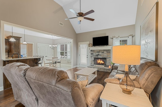 1640 Drayton Dr, Murfreesboro, TN 37130 - living room featuring high vaulted ceiling, dark wood-type flooring, a ceiling fan, a stone fireplace, and a chandelier