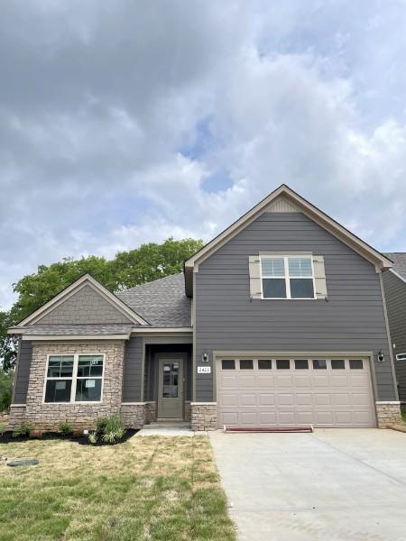 2618 Unitas Dr, Murfreesboro, TN 37129 - view of front of house featuring an attached garage, driveway, stone siding, a front yard, and roof with shingles