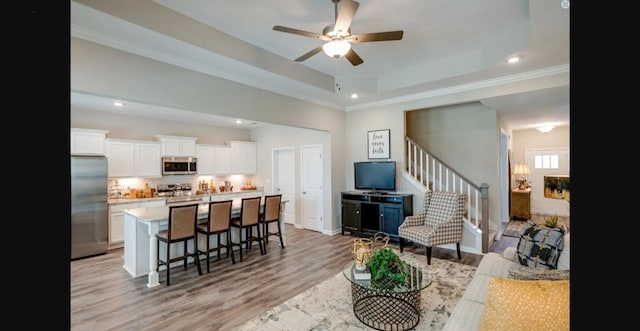 2618 Unitas Dr, Murfreesboro, TN 37129 - living room with light wood finished floors, ceiling fan, stairway, recessed lighting, and a raised ceiling