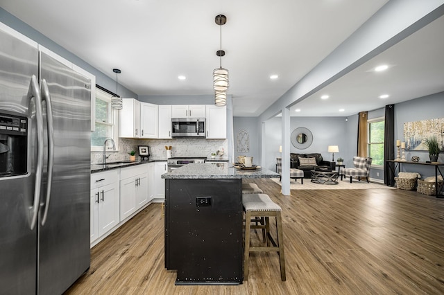 2422 Choctaw Trce, Murfreesboro, TN 37129 - kitchen featuring appliances with stainless steel finishes, wood finished floors, backsplash, a center island, and white cabinetry