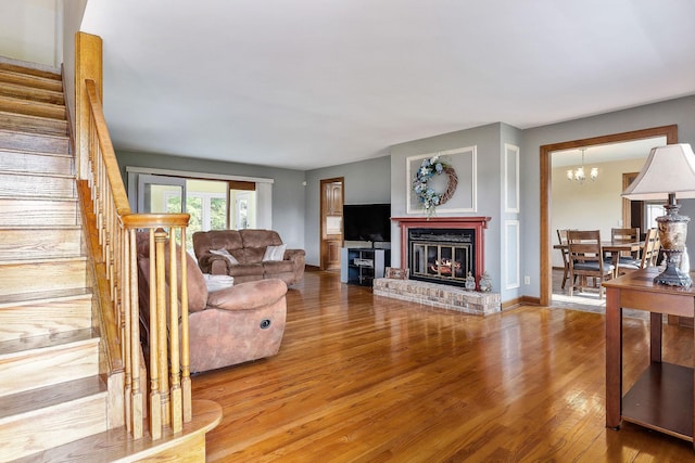 40 Lakeview Trl, Mcminnville, TN 37110 - living area featuring wood finished floors, stairs, a brick fireplace, and a chandelier