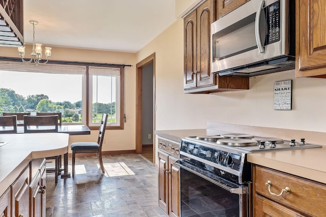 40 Lakeview Trl, Mcminnville, TN 37110 - kitchen with stainless steel microwave, electric range, stone finish flooring, brown cabinets, and light countertops