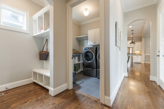 1202 Jewell Ave, Franklin, TN 37064 - laundry area featuring washer and dryer, cabinet space, arched walkways, ornamental molding, and dark wood finished floors