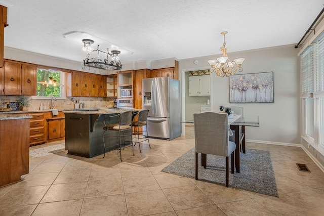 305 E Overhill Dr, Dickson, TN 37055 - kitchen with stainless steel appliances, a chandelier, brown cabinets, and a textured ceiling