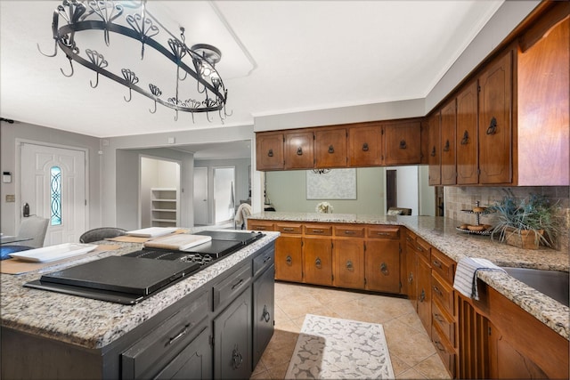 305 E Overhill Dr, Dickson, TN 37055 - kitchen featuring brown cabinetry, tasteful backsplash, a kitchen island, and light tile patterned floors