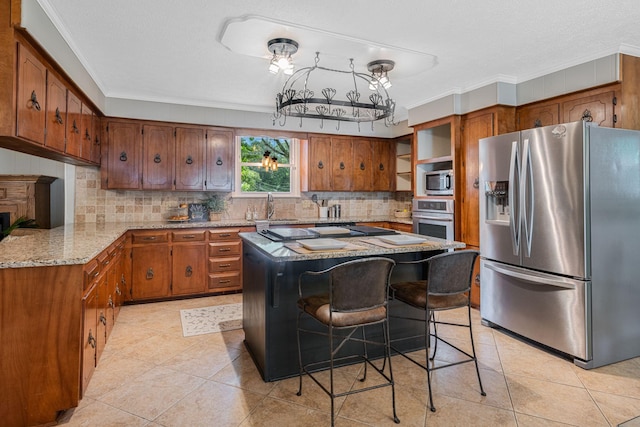 305 E Overhill Dr, Dickson, TN 37055 - kitchen with appliances with stainless steel finishes, ornamental molding, backsplash, brown cabinets, and a kitchen island