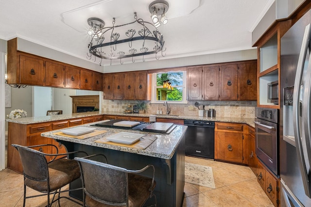 305 E Overhill Dr, Dickson, TN 37055 - kitchen featuring black appliances, tasteful backsplash, ornamental molding, brown cabinetry, and a kitchen island