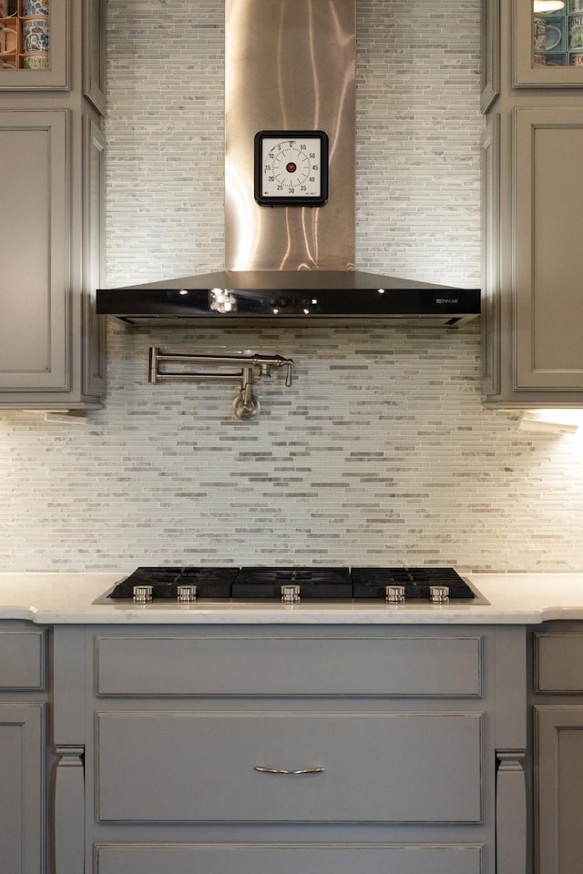 9488 Stillbrook Trce, Brentwood, TN 37027 - kitchen featuring gray cabinetry, wall chimney exhaust hood, decorative backsplash, and glass insert cabinets