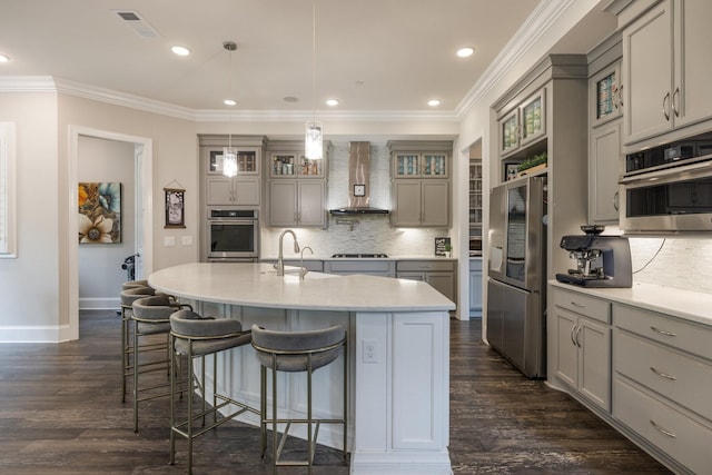 9488 Stillbrook Trce, Brentwood, TN 37027 - kitchen with appliances with stainless steel finishes, wall chimney range hood, gray cabinets, decorative backsplash, and a breakfast bar