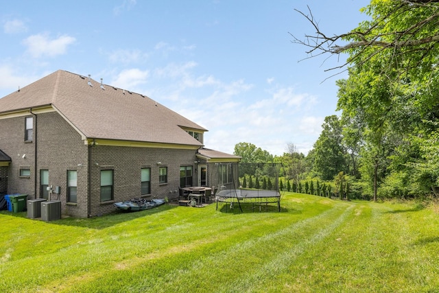 9488 Stillbrook Trce, Brentwood, TN 37027 - back of house featuring a trampoline, a lawn, roof with shingles, and brick siding