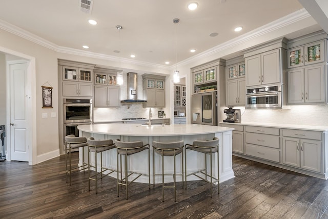 9488 Stillbrook Trce, Brentwood, TN 37027 - kitchen with refrigerator with ice dispenser, double oven, gray cabinetry, wall chimney exhaust hood, and a breakfast bar area