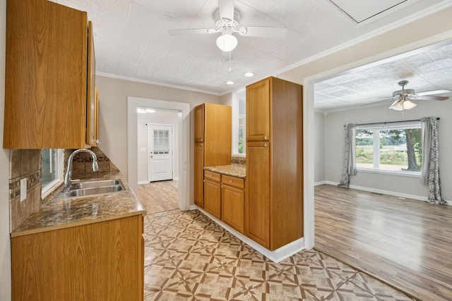 631 W Maple St, Morrison, TN 37357 - kitchen featuring a ceiling fan, brown cabinetry, light wood-type flooring, crown molding, and open floor plan