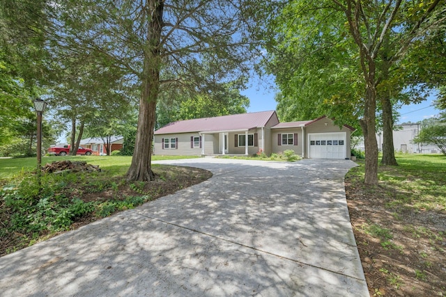 631 W Maple St, Morrison, TN 37357 - single story home with concrete driveway, a garage, a front lawn, and a metal roof