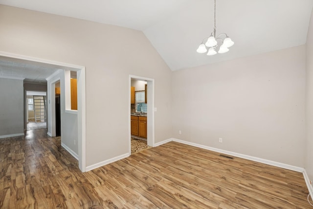 631 W Maple St, Morrison, TN 37357 - spare room with wood finished floors, a chandelier, and vaulted ceiling