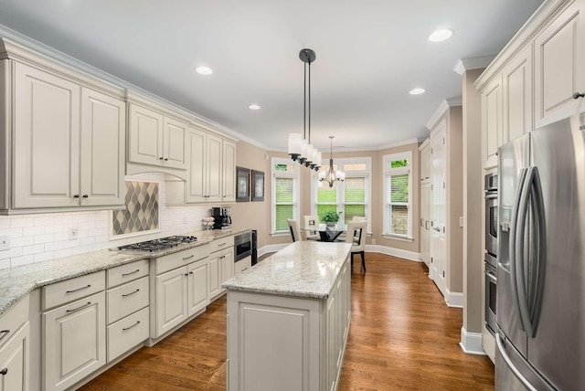 241 King Arthur Cir, Franklin, TN 37067 - kitchen with appliances with stainless steel finishes, a chandelier, backsplash, a center island, and ornamental molding