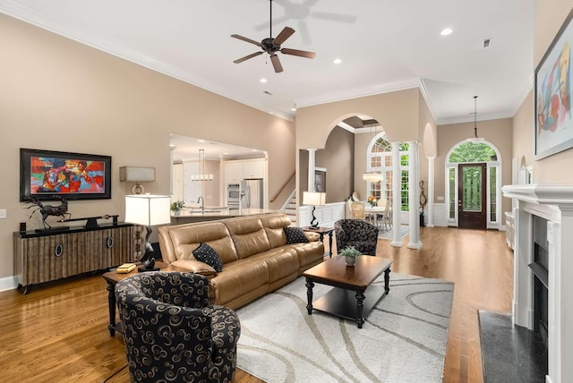 241 King Arthur Cir, Franklin, TN 37067 - living area featuring ceiling fan, light wood-style flooring, arched walkways, a fireplace, and stairway