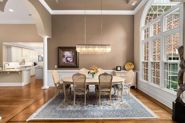 241 King Arthur Cir, Franklin, TN 37067 - dining area featuring dark wood-style floors, ornamental molding, decorative columns, a chandelier, and arched walkways