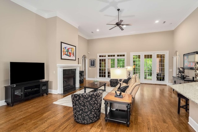 241 King Arthur Cir, Franklin, TN 37067 - living area featuring a fireplace with flush hearth, wood finished floors, ceiling fan, crown molding, and a high ceiling