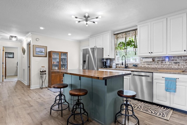 1060 Anderson Ridge Rd, Jasper, TN 37347 - kitchen featuring appliances with stainless steel finishes, butcher block counters, light wood-style floors, white cabinetry, and a textured ceiling