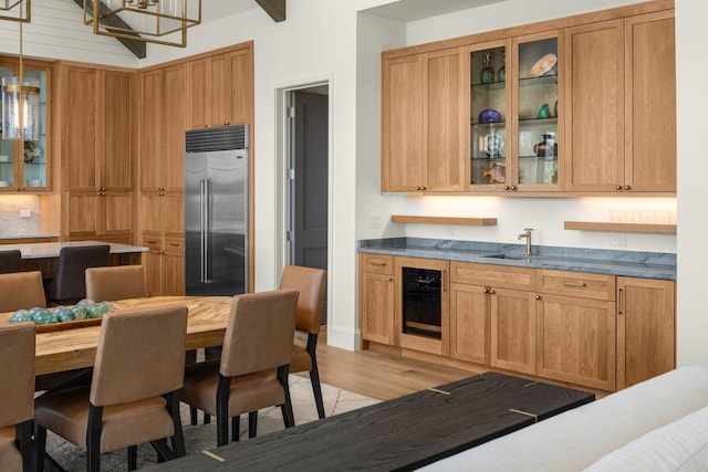 7346 Harlow Dr, College Grove, TN 37046 - kitchen with stainless steel built in refrigerator, beverage cooler, light wood-style flooring, and glass insert cabinets