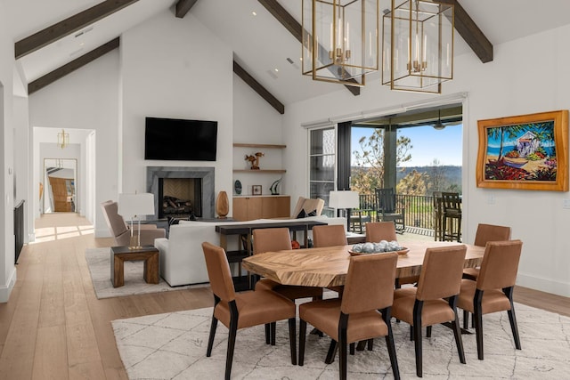 7346 Harlow Dr, College Grove, TN 37046 - dining room featuring beam ceiling, light wood finished floors, high vaulted ceiling, a chandelier, and a premium fireplace