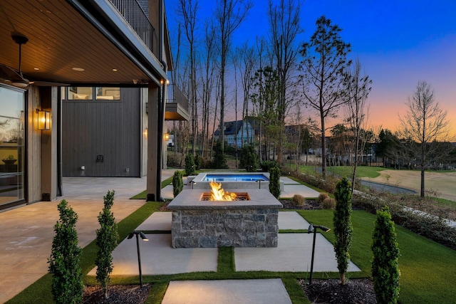 7346 Harlow Dr, College Grove, TN 37046 - patio terrace at dusk with a patio, a fire pit, and a lawn