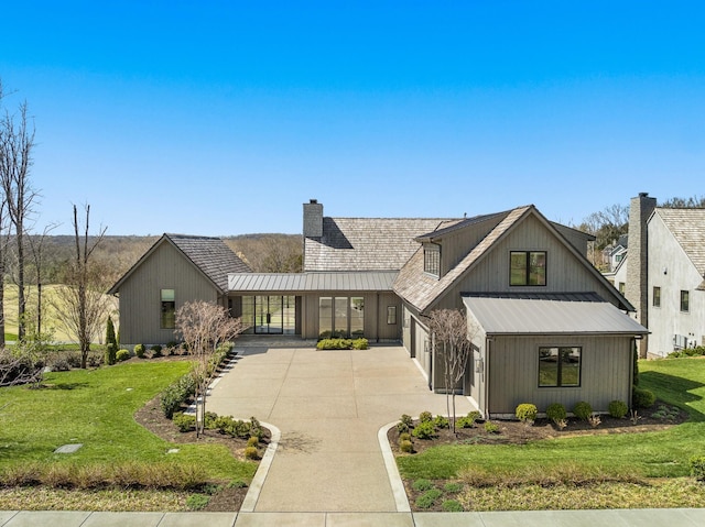 7346 Harlow Dr, College Grove, TN 37046 - modern inspired farmhouse featuring concrete driveway, a chimney, a front yard, and a standing seam roof
